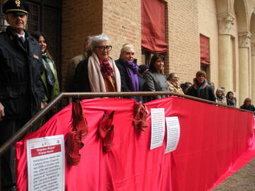 Scarpe rosse e drappo rosso esposti in Castello Estense